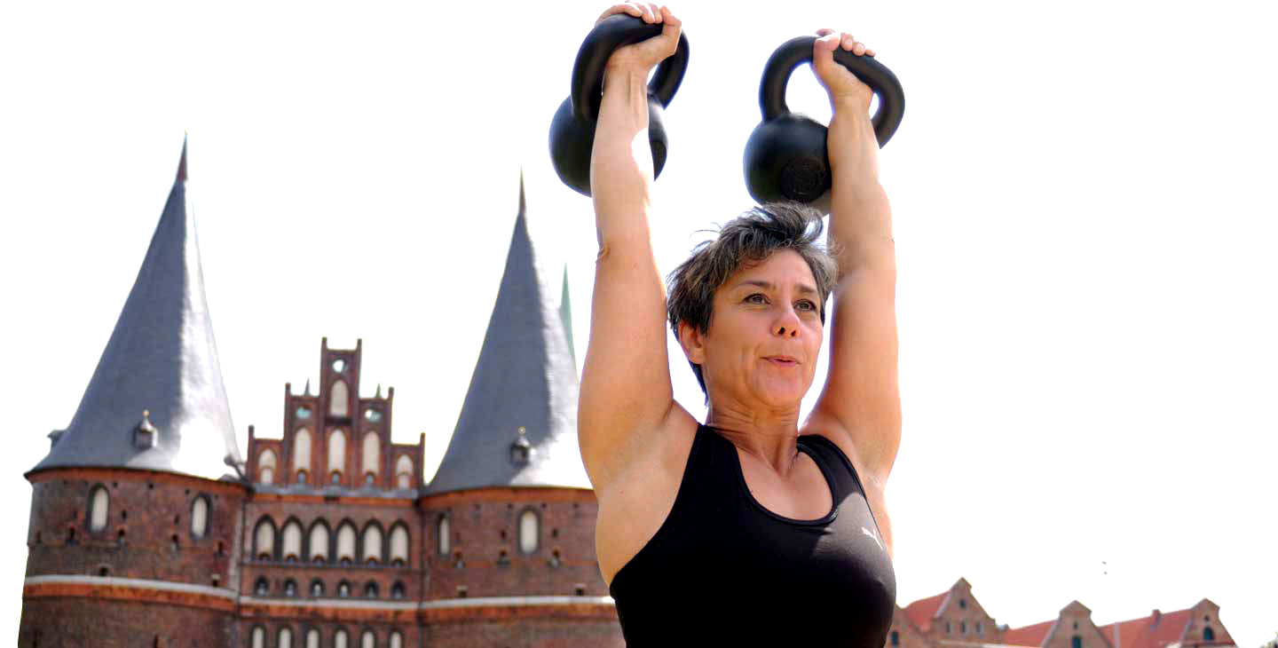 Personal Trainer Lübeck: Martina Korte, mit Kugelhanteln vor dem Lübecker Holstentor
